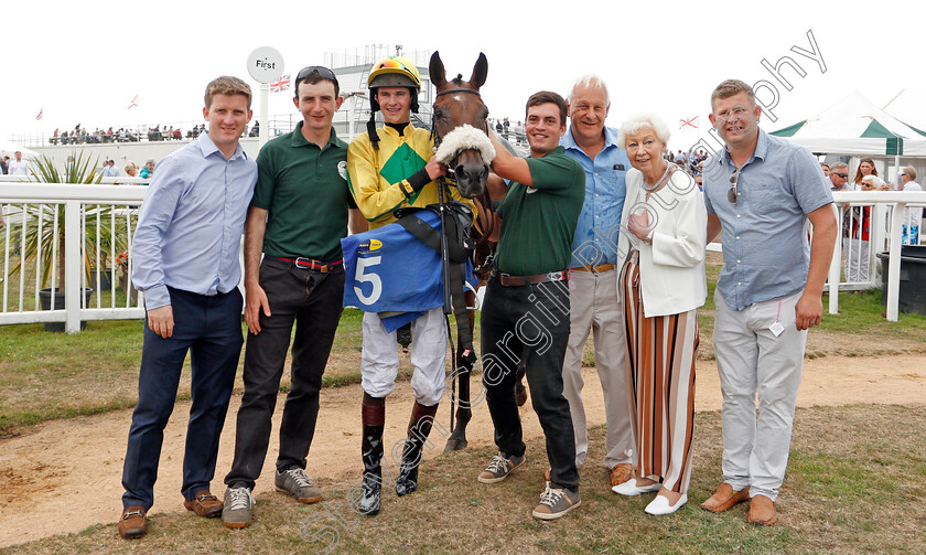 Molliana-0008 
 MOLLIANA (Brendan Powell) with trainer Neil Mulholland (left) and owner Mike Burbidge (3rd right) after The Oakbridge Clarendon Handicap
Les Landes, Jersey 26 Aug 2019 - Pic Steven Cargill / Racingfotos.com